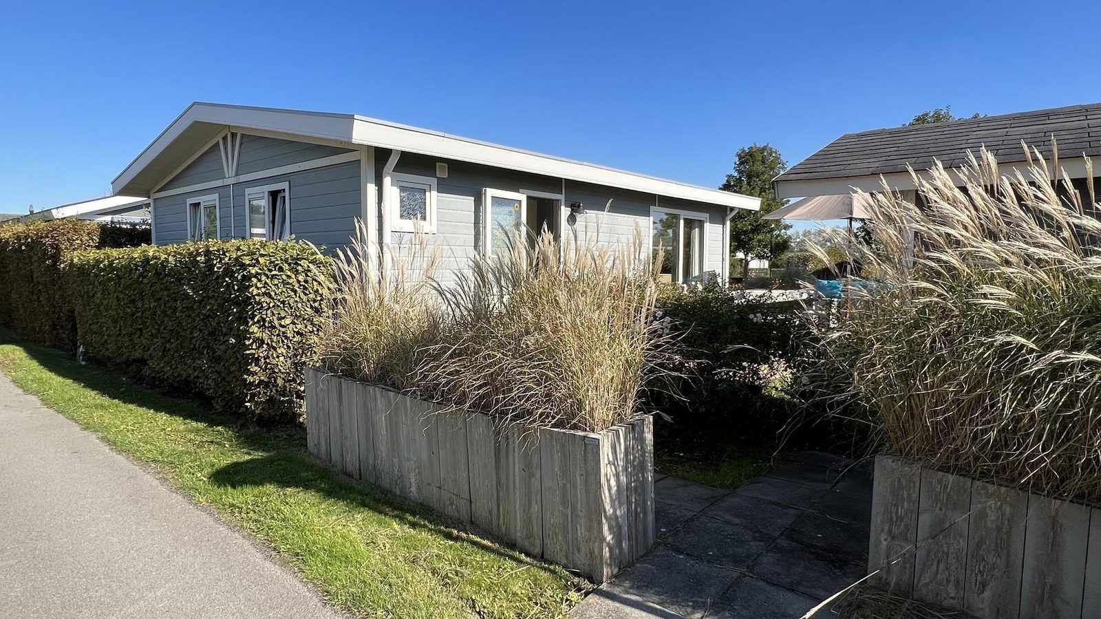 Vorderansicht von VZ808 Ferienhaus in Breskens mit gruenem Zaun, Zeeland.