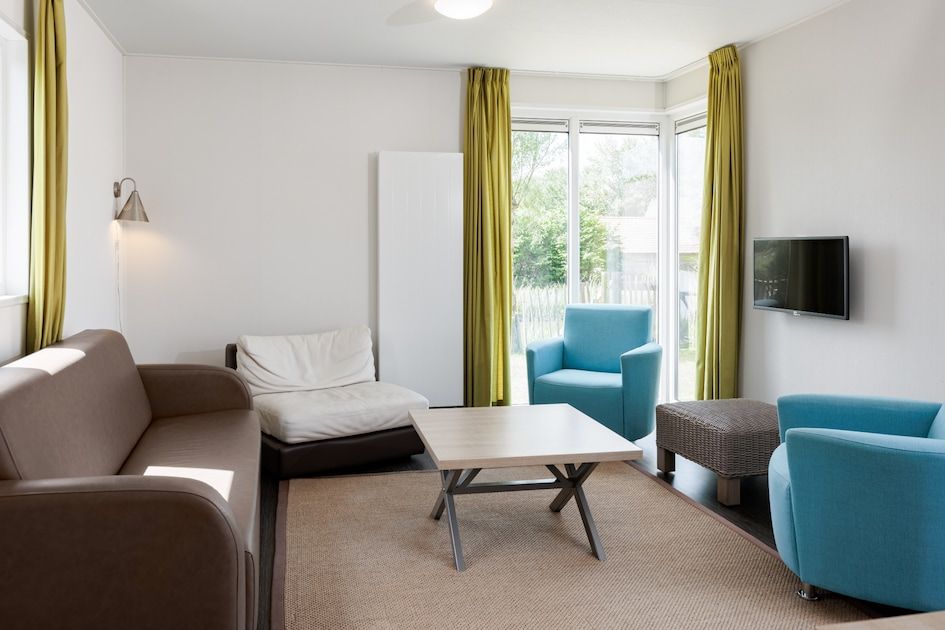 Cozy living room of Lodge 6C, a vacation home in Breskens, Zeeuws-Vlaanderen, Zeeland with modern furniture and lots of natural light.