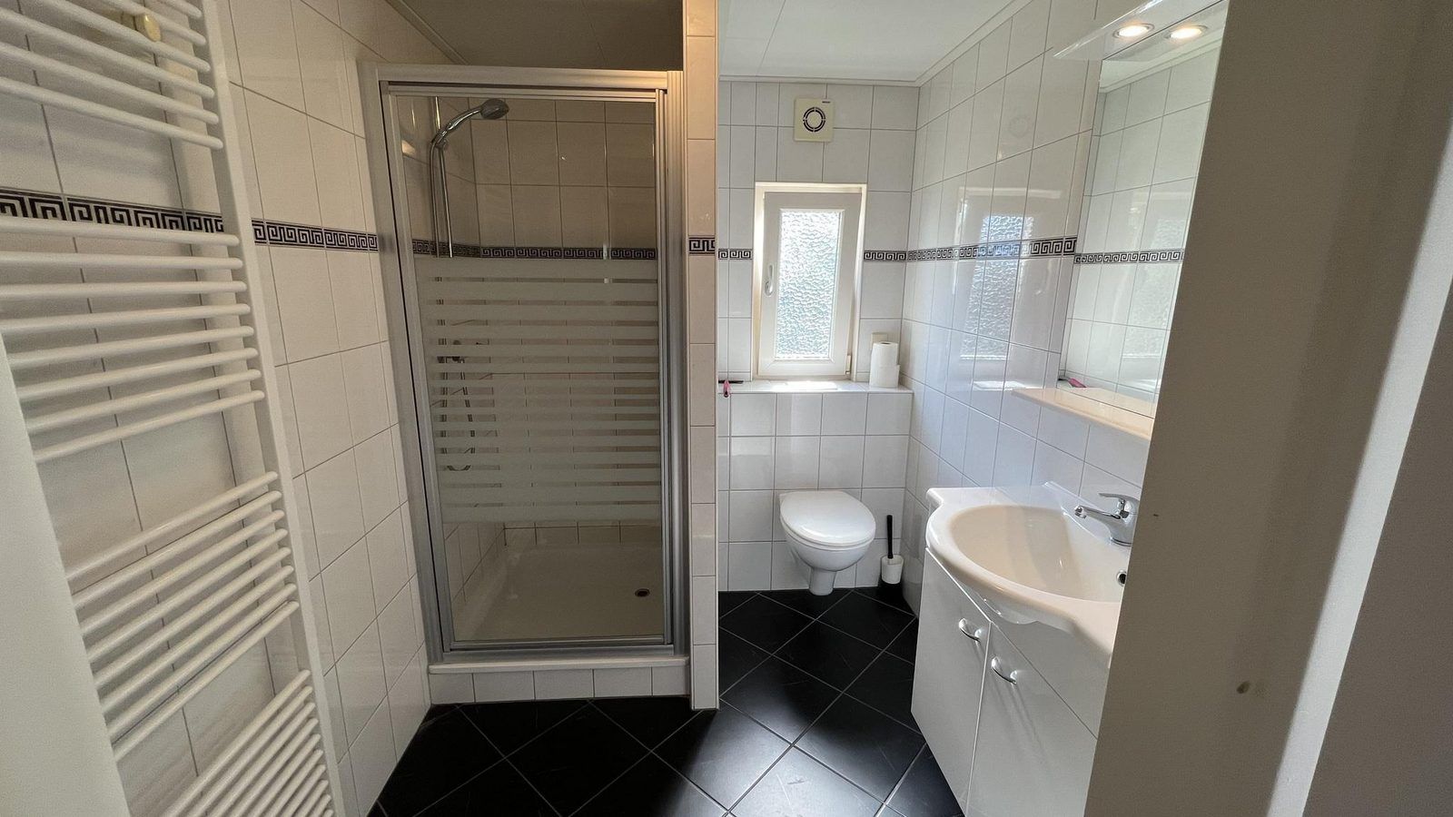 Stilvolles Badezimmer in VZ807 Ferienhaus Breskens mit Dusche und Waschbecken in Zeeland.