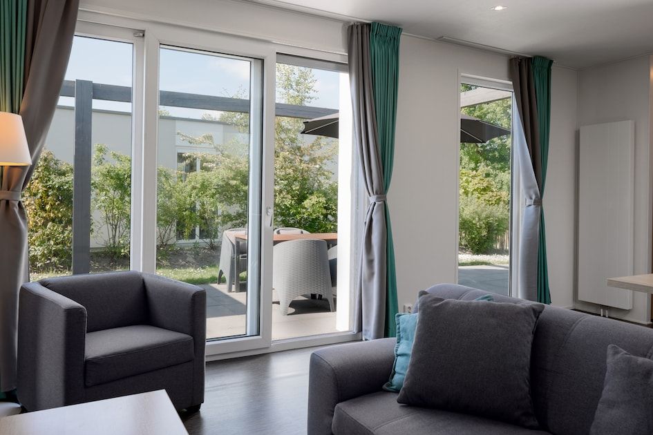 Gezellige binnenruimte van Lodge 4B in Breskens, Zeeland, met uitzicht op de groene tuin en terras.