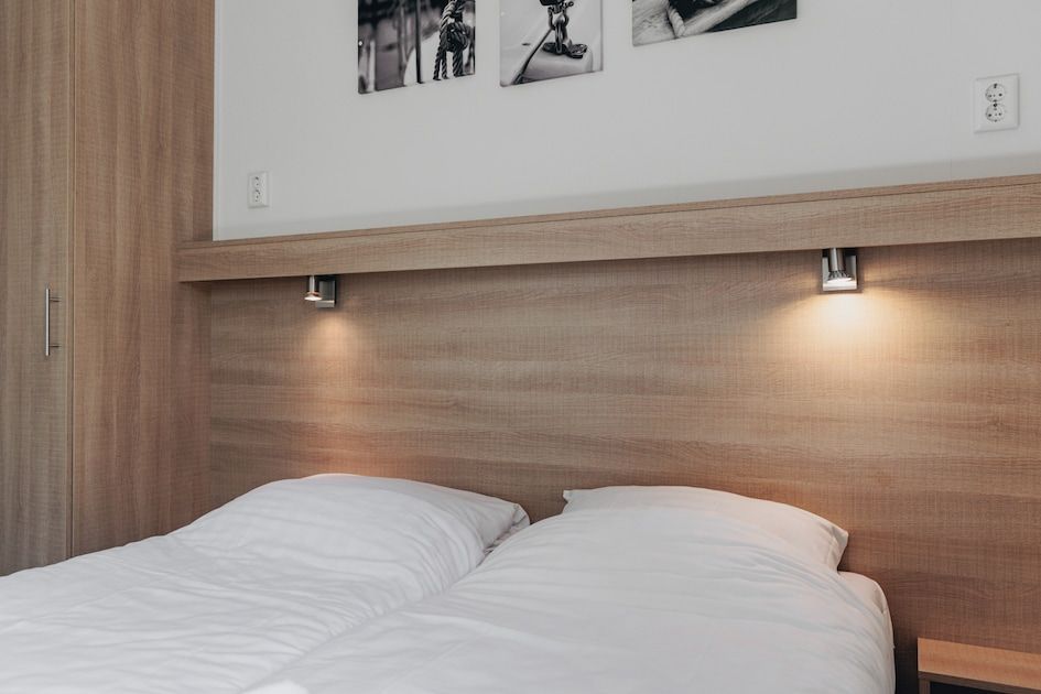 Comfortabele slaapkamer in Lodge 4B, Breskens, Zeeuws-Vlaanderen, met tweepersoonsbed en warme verlichting.