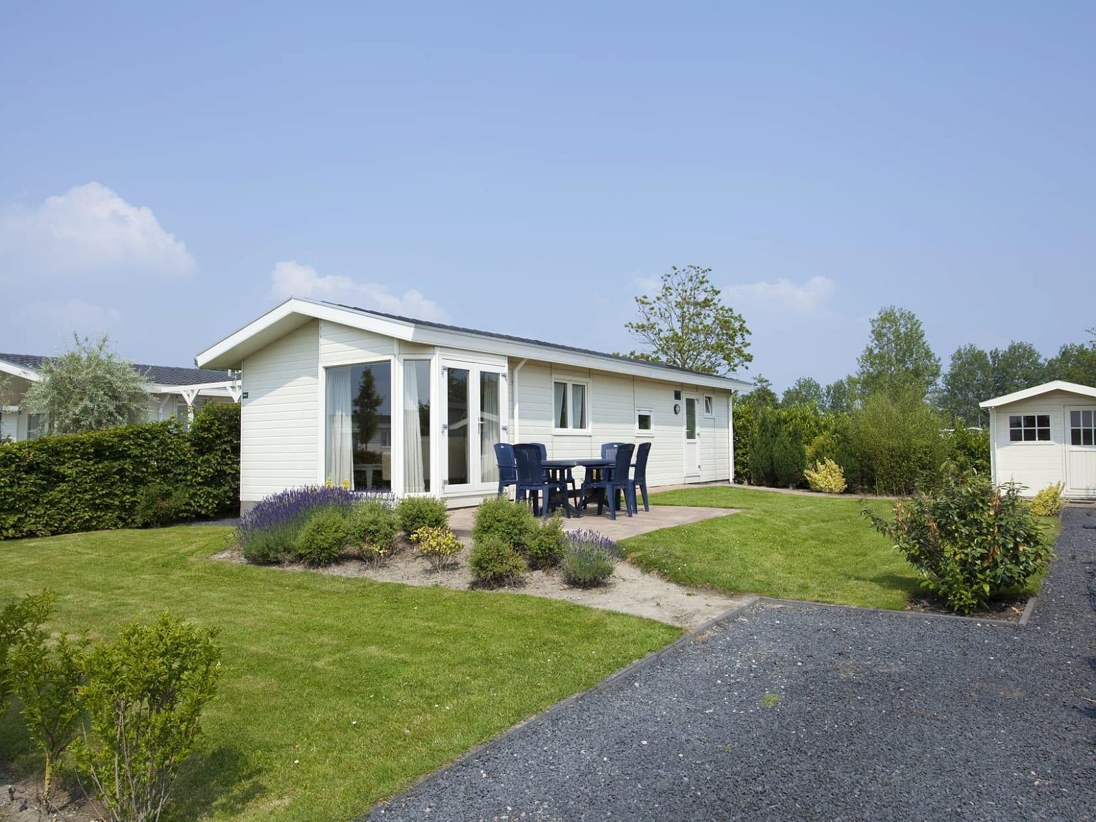 Geniet van de rust bij vakantiehuis Unique Luxe 4 in Breskens, Zeeland, met een prachtig terras en groene tuin omgeven door natuur.