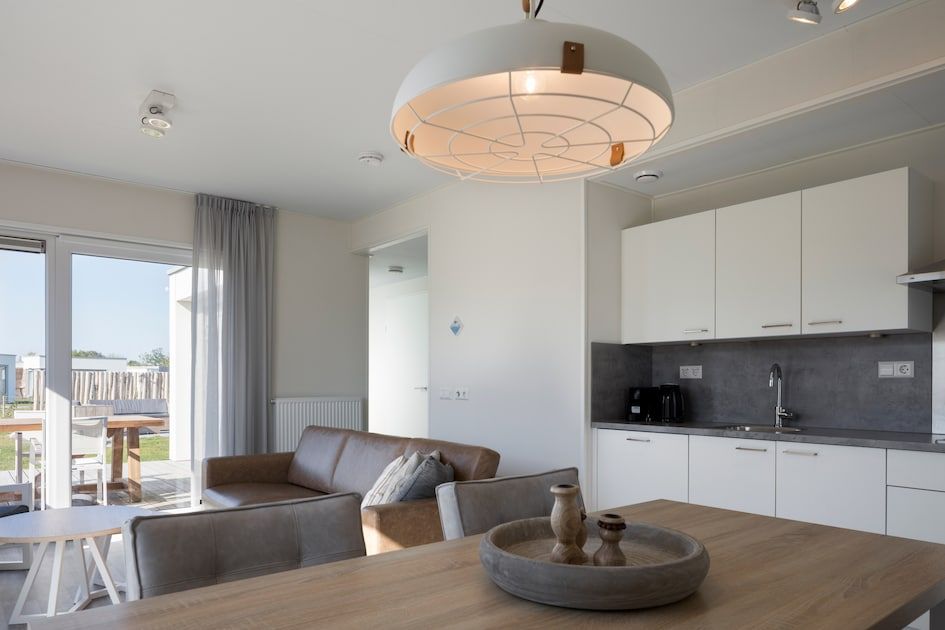 Moderne binnenruimte van L4A Comfort vakantiehuis in Nieuwvliet-Bad, Zeeland met open keuken en uitzicht op het terras.