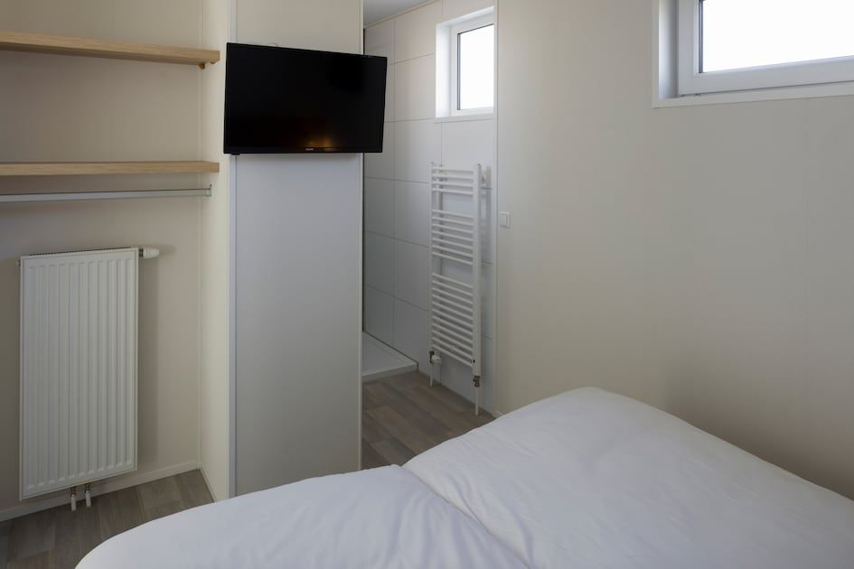 Moderne slaapkamer in L4A Comfort vakantiehuis, Nieuwvliet-Bad, Zeeuws-Vlaanderen, met comfortabele faciliteiten en serene sfeer.