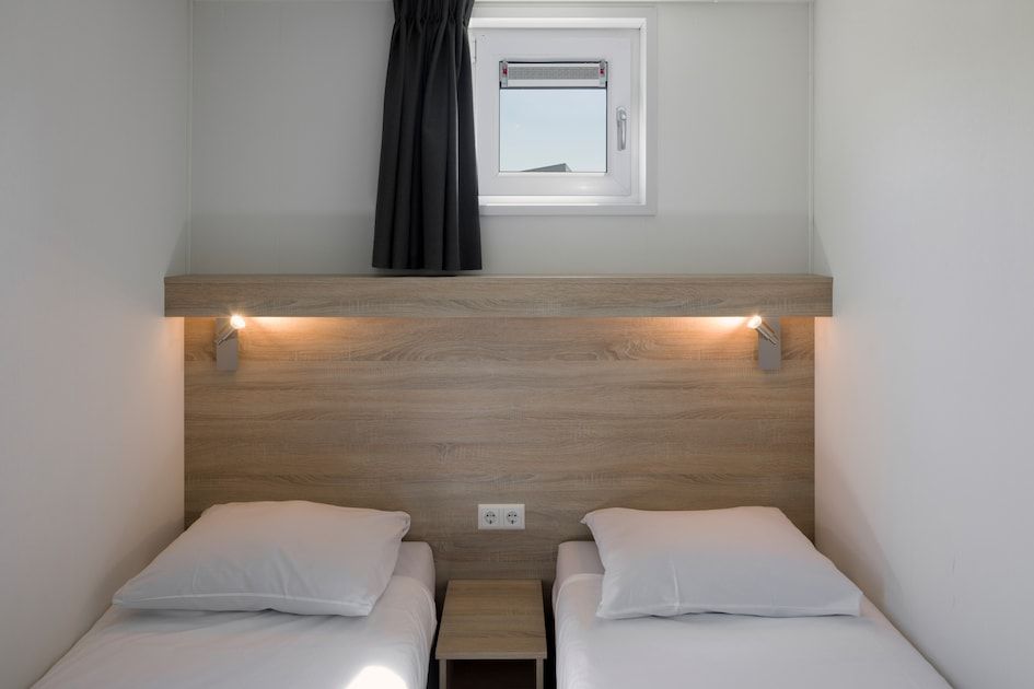 Schlafzimmer in L6B Komfort-Ferienhaus in Nieuwvliet-Bad, Zeeland mit Gartenblick und moderner Ausstattung.