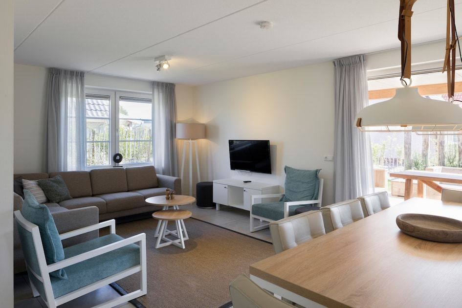 Gemuetliches Wohnzimmer im V8 Luxus-Ferienhaus in Nieuwvliet-Bad, Zeeland, mit komfortabler Sitzecke.