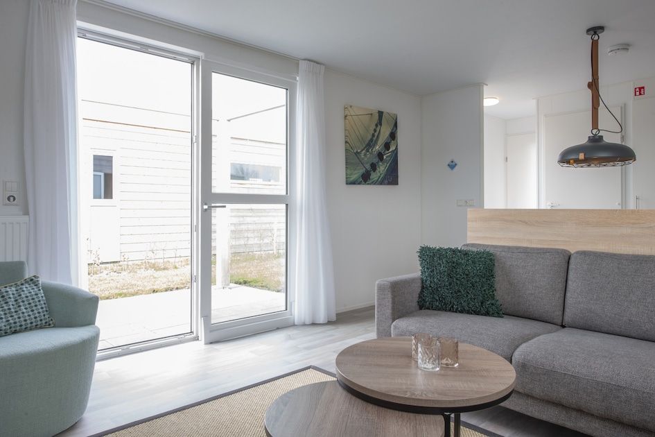 Lichte woonkamer van L6 Comfort vakantiehuis in Nieuwvliet-Bad, Zeeland, met moderne inrichting en uitzicht op het terras.