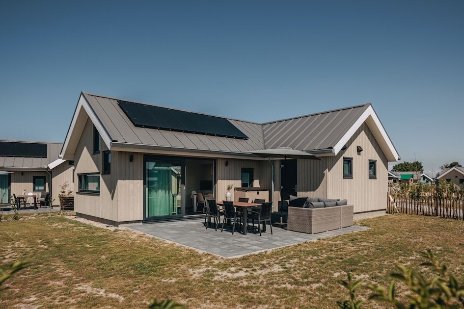 Die Babylodge 4+1 in Nieuwvliet-Bad, ein Ferienhaus in Zeeland, bietet eine einladende Terrasse und einen modernen Aussenbereich zum Entspannen.