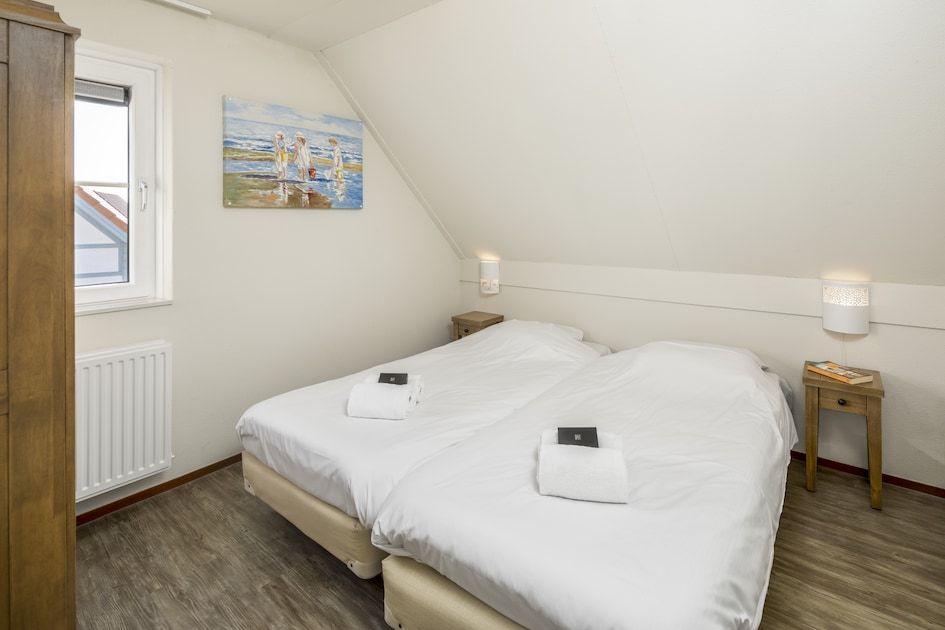 Moderne badkamer in Villa 5A, een vakantiehuis in Cadzand-bad, Zeeuws-Vlaanderen, Zeeland met ruime wastafel en natuurlijk daglicht.