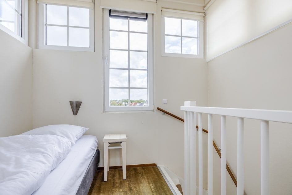 Sfeervolle slaapkamer in Villa 9A, vakantiehuis in Cadzand-bad, Zeeuws-Vlaanderen, Zeeland, met twee comfortabele bedden en natuurlijk licht.