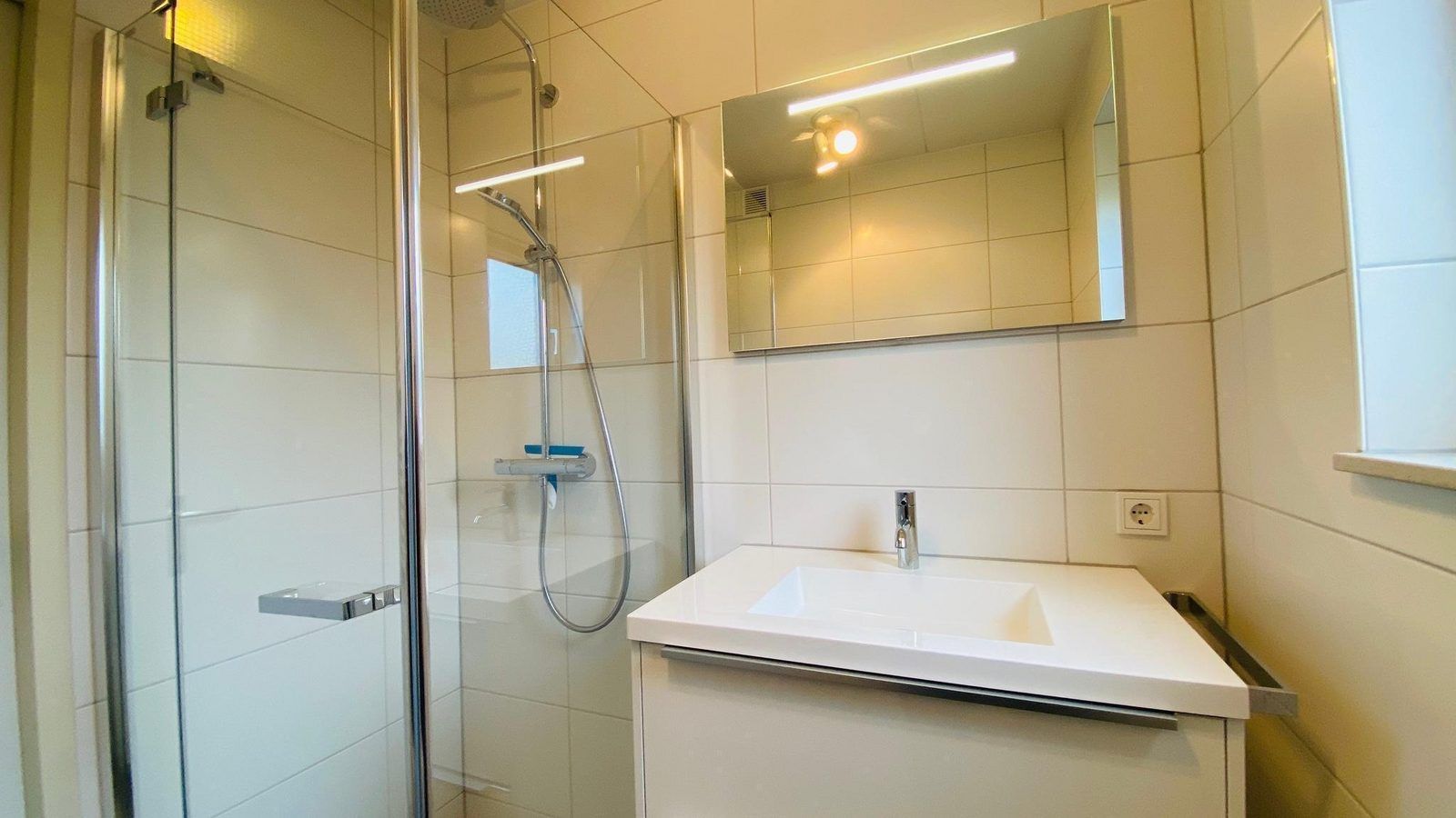 Shower and sink in the bathroom of VZ921 Holiday home in Cadzand-Bad, Zeeland.