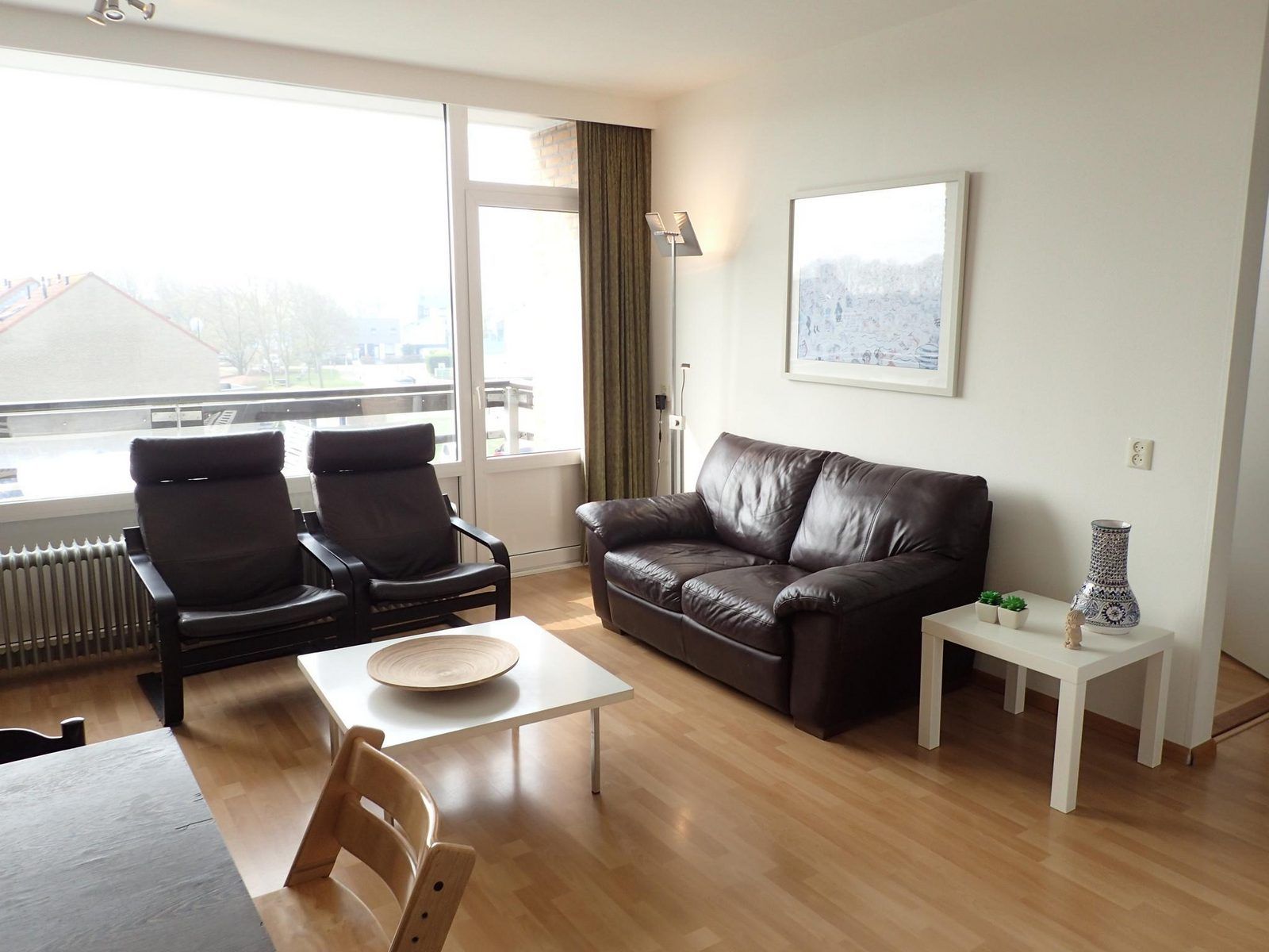 Gemuetliches Wohnzimmer der Ferienwohnung VZ922 in Cadzand, mit Ledersofa und grossen Fenstern fuer viel Licht.