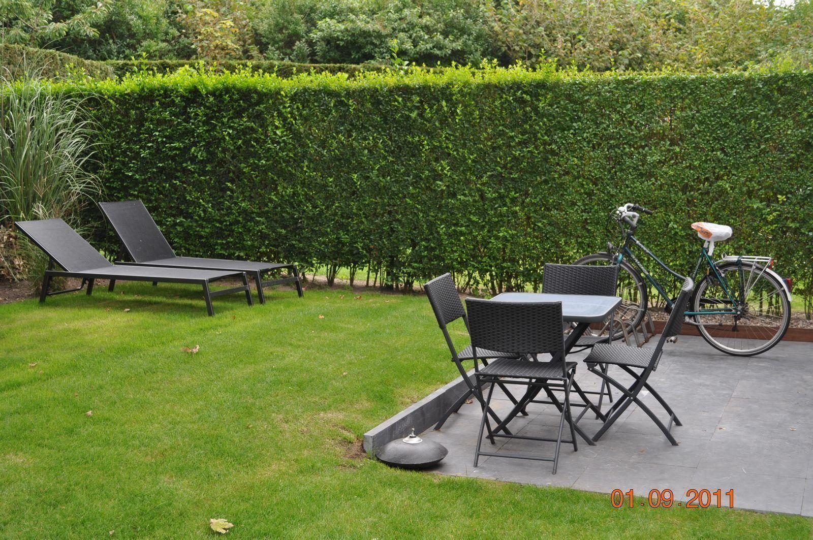 Tuin met ligstoelen bij VZ702 Vakantiehuis Cadzand in Cadzand, Zeeuws-Vlaanderen, perfect voor ontspanning.