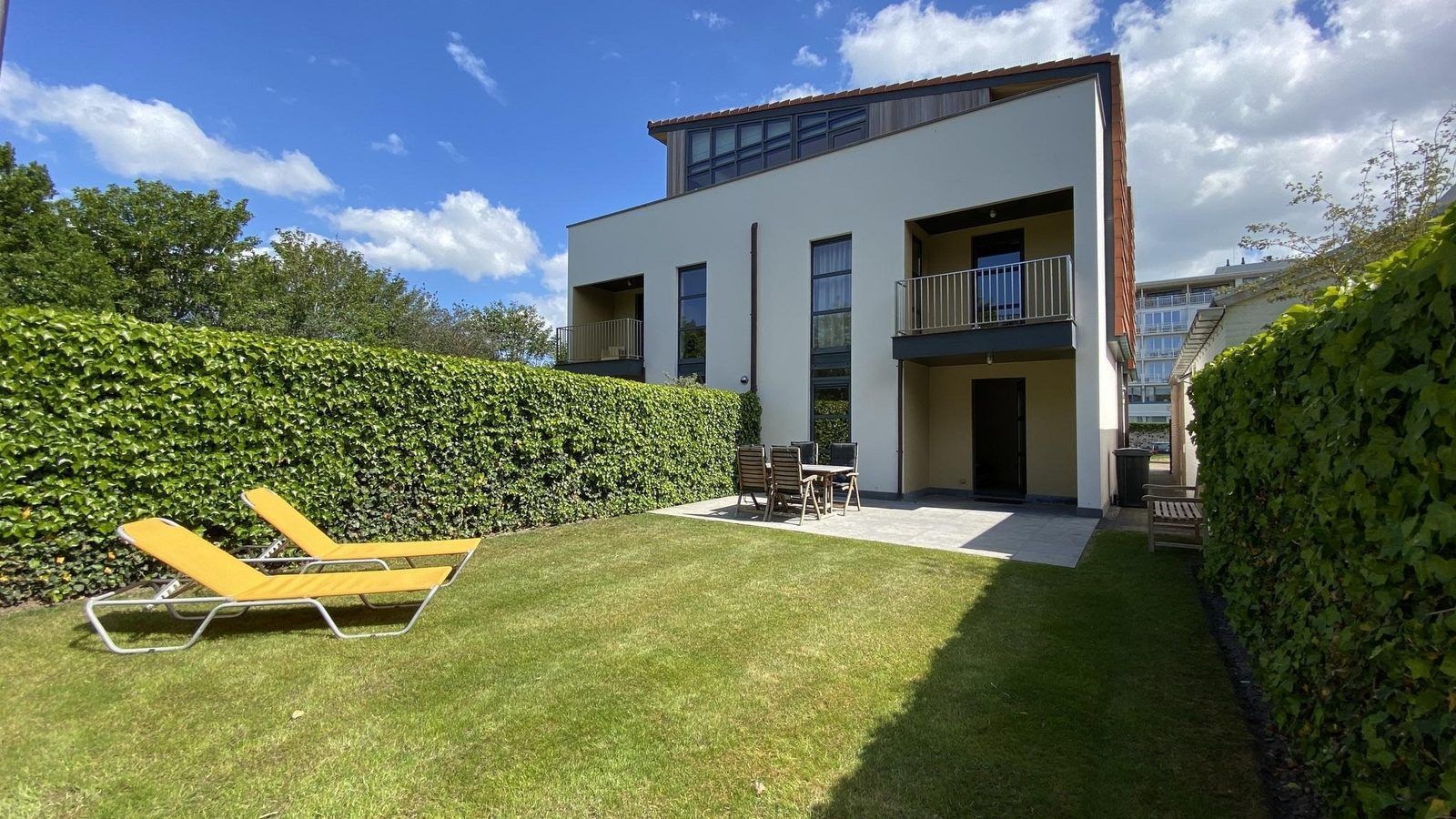 VZ193 Appartement Cadzand in Zeeuws-Vlaanderen biedt een groene tuin met terras en ligstoelen in Cadzand, Zeeland.