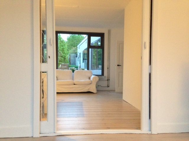 Lichte binnenruimte in vakantiehuis Landstraat, Aardenburg, Zeeuws-Vlaanderen met toegang tot tuin.