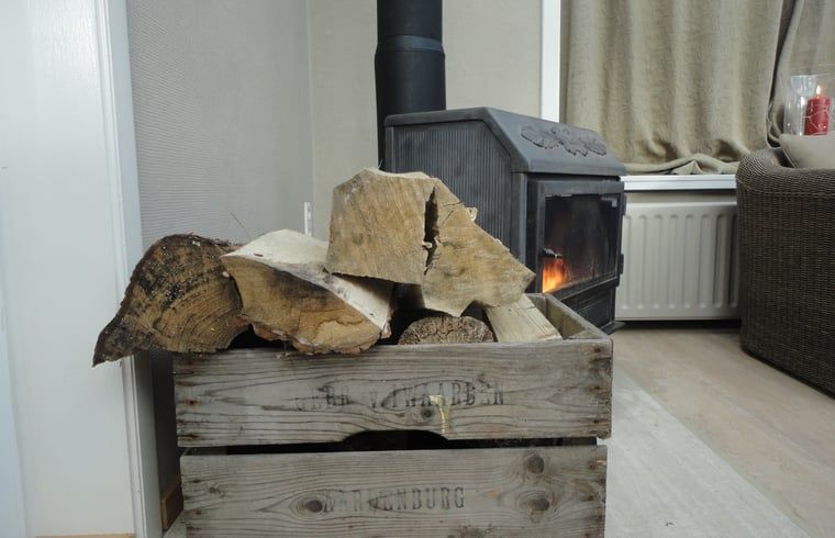 Gezellige houtkachel in Vakantiehuis in Sluis, Zeeuws-Vlaanderen, Zeeland, straalt warmte uit in de woonkamer van dit vakantieverblijf.