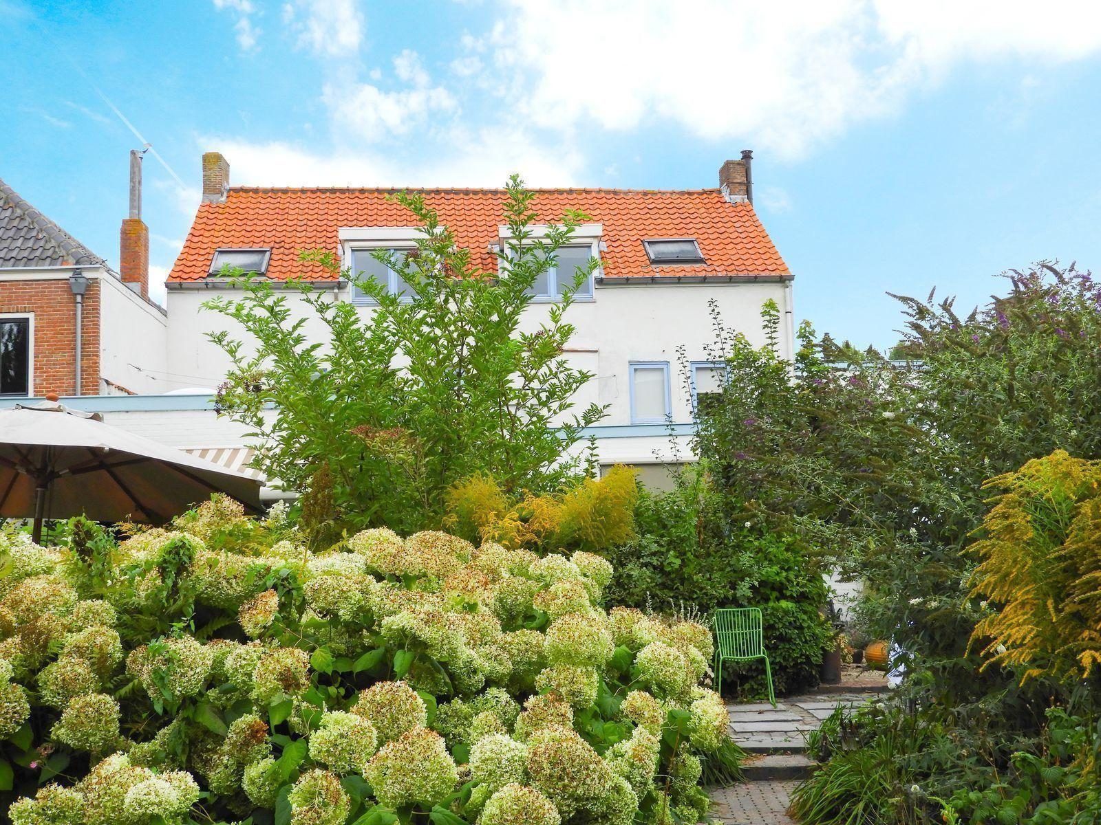 Exterior of VZ052 Apartment Sluis in Sluis, Zeeuws-Vlaanderen, surrounded by lush garden.