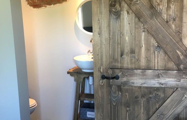 Laendliche Badezimmertuer und Mobiliar im Ferienhaus Cottage in Axel, Zeeland.