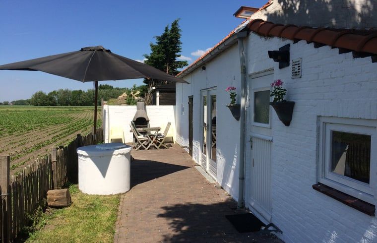 Zonnig terras bij Vakantiehuis in Walsoorden, Zeeuws-Vlaanderen, perfect voor ontspanning in Zeeland.
