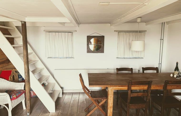 Knusse zithoek in Vakantiehuis in Walsoorden, Zeeuws-Vlaanderen, met comfortabele bank en houten muren.