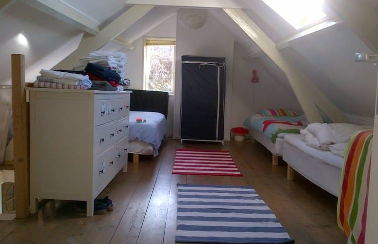 Knusse slaapkamer in Vakantiehuis in Walsoorden, Zeeuws-Vlaanderen, met houten plafond en sfeervolle lamp.