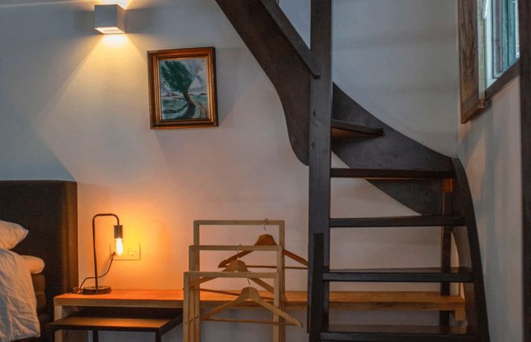 Schoenes Schlafzimmer im Ferienhaus Walsoorden, Zeeuws-Vlaanderen, mit Holztreppe.