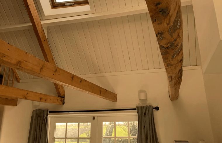 Rustikale Holzbalken im Ferienhaus Walsoorden, Zeeuws-Vlaanderen, mit viel Licht.