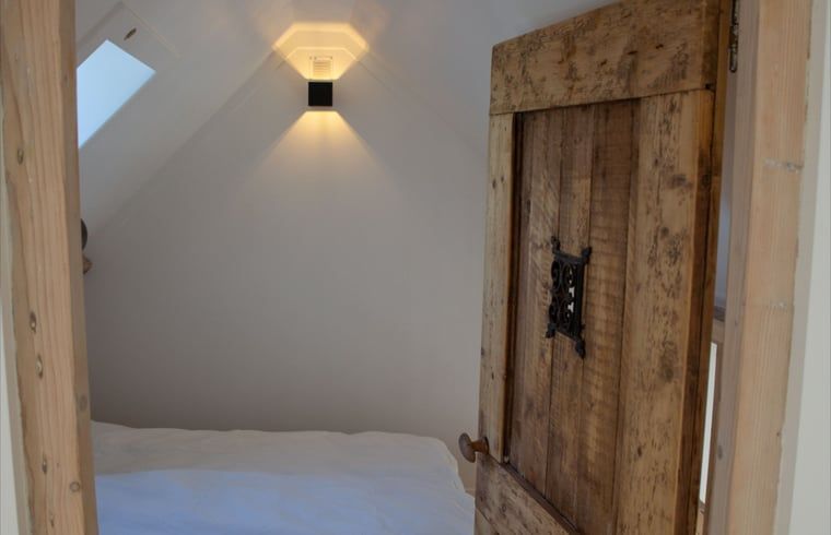 Schoenes Schlafzimmer im Ferienhaus Walsoorden, Zeeuws-Vlaanderen, mit Holztuer.