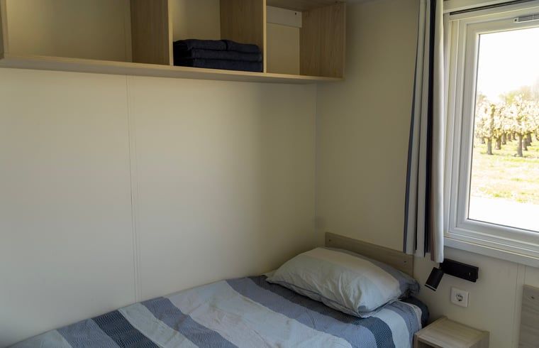 Gezellige slaapkamer in Vakantiehuisje in Hengstdijk, Zeeuws-Vlaanderen, met comfortabele bedden en uitzicht op de rustige natuur van Zeeland.