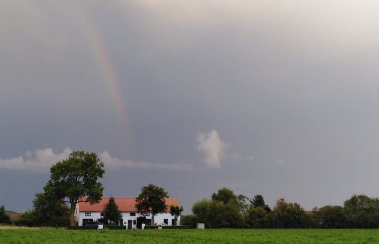 Prachtige regenboog boven Vakantiehuisje in IJzendijke, omgeven door natuur.