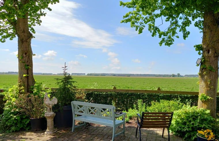 Rustige tuin met uitzicht bij Vakantiehuisje in IJzendijke, Zeeuws-Vlaanderen.