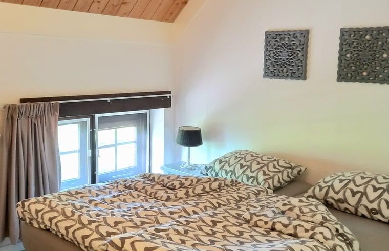 Slaapkamer met uitzicht in Vakantiehuisje in IJzendijke, Zeeuws-Vlaanderen, Zeeland.