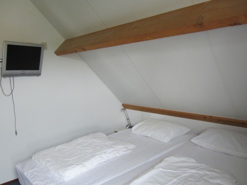 Bedroom in Vermare vacation home, Wemeldinge, South Beveland, with double bed and television.