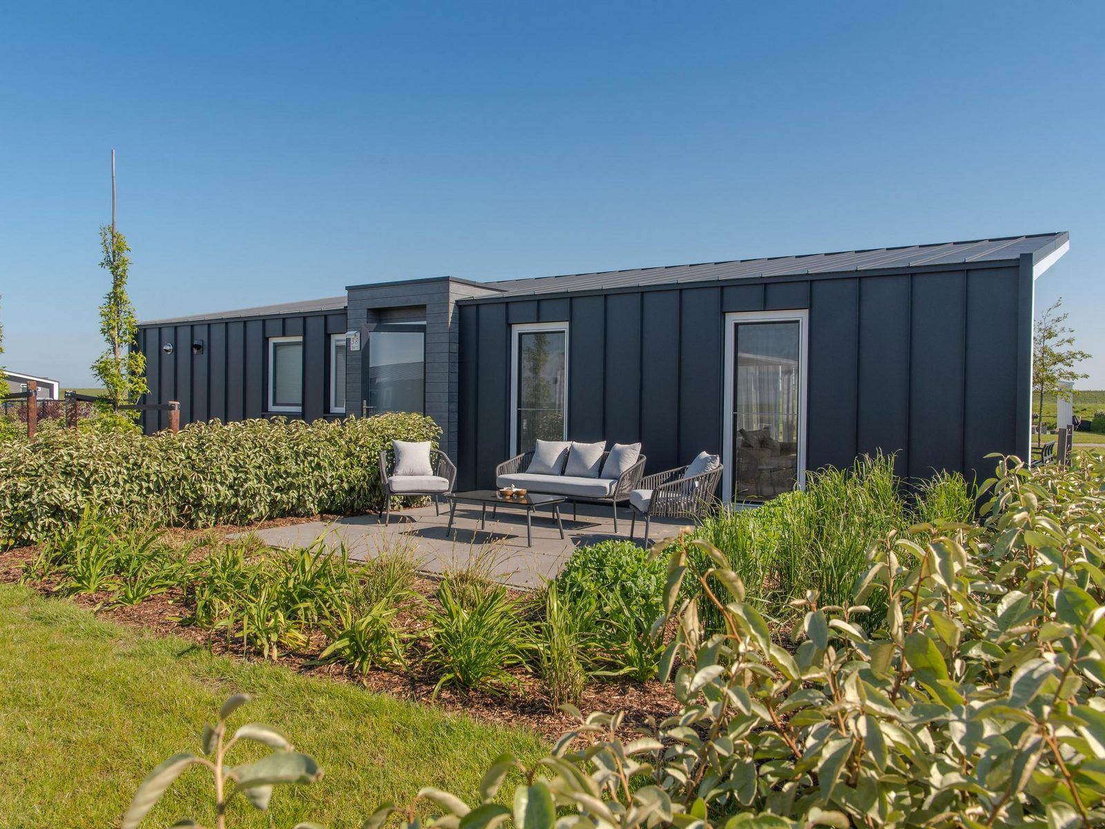 Vacation home Waterresort Oosterschelde - house no. 38 in Wemeldinge with modern exterior and green garden.