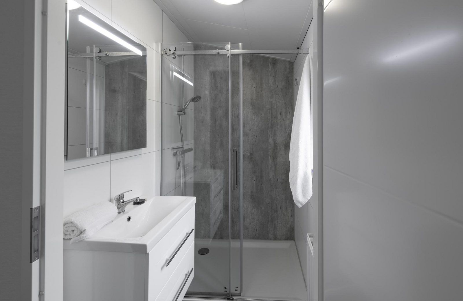 Modernes Badezimmer im Ferienhaus Waterresort Oosterschelde Haus Nr. 91, Wemeldinge, mit begehbarer Dusche und schlichtem Design.