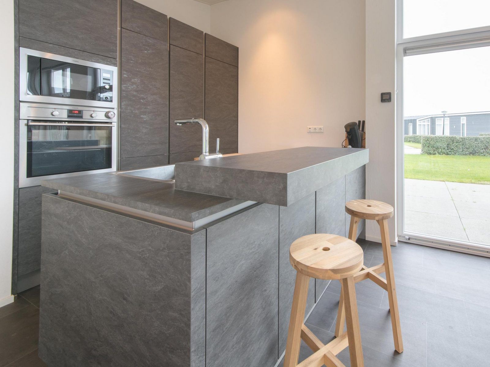 Kuechentheke im Ferienhaus Waterresort Oosterschelde Haus Nr. 91, Wemeldinge, mit moderner Ausfuehrung und stilvollen Hockern.