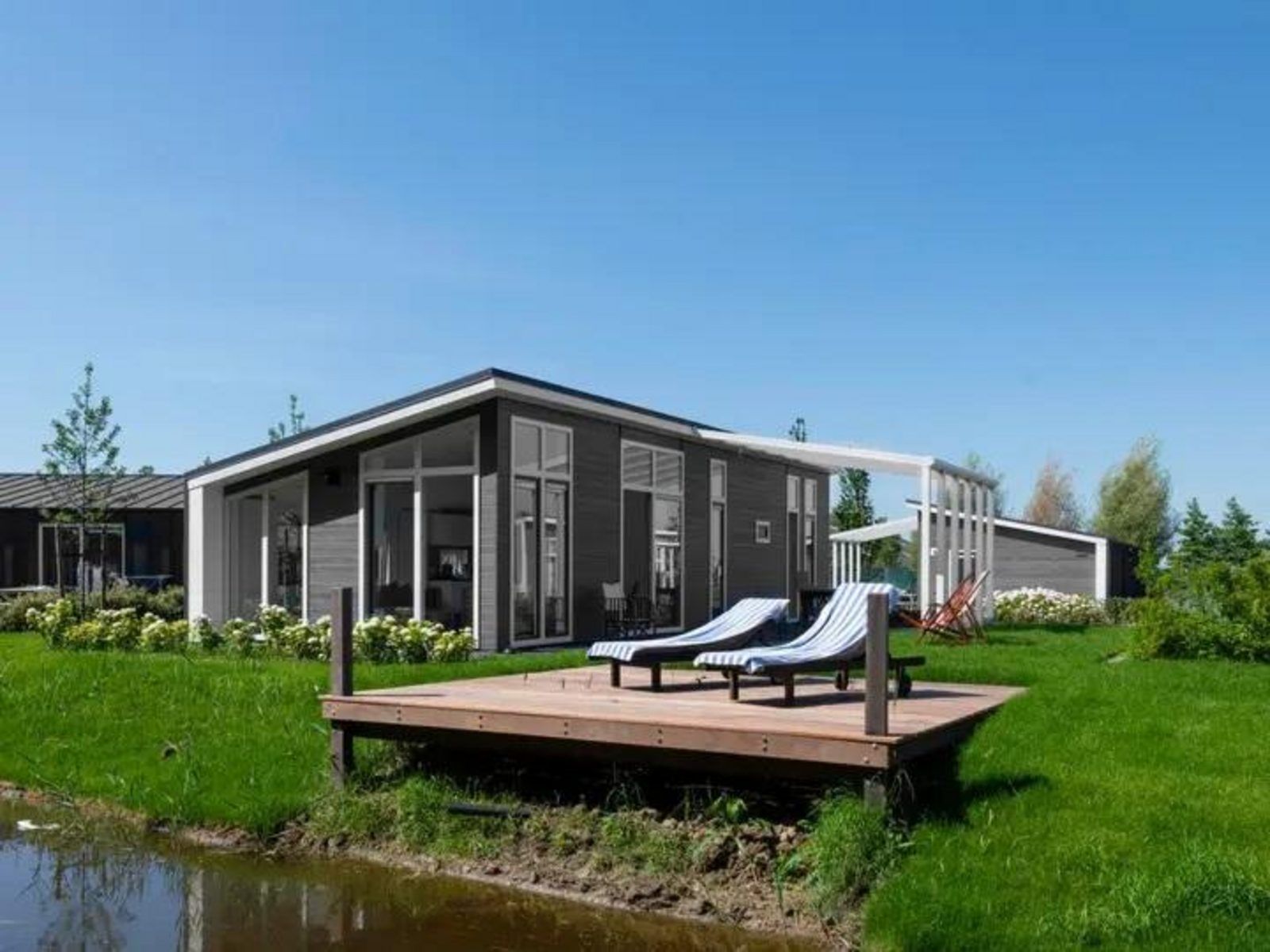 Ferienhaus Waterresort Oosterschelde in Wemeldinge mit Sonnenterrasse und Liegestuehlen, ideal fuer Entspannung in Zeeland.
