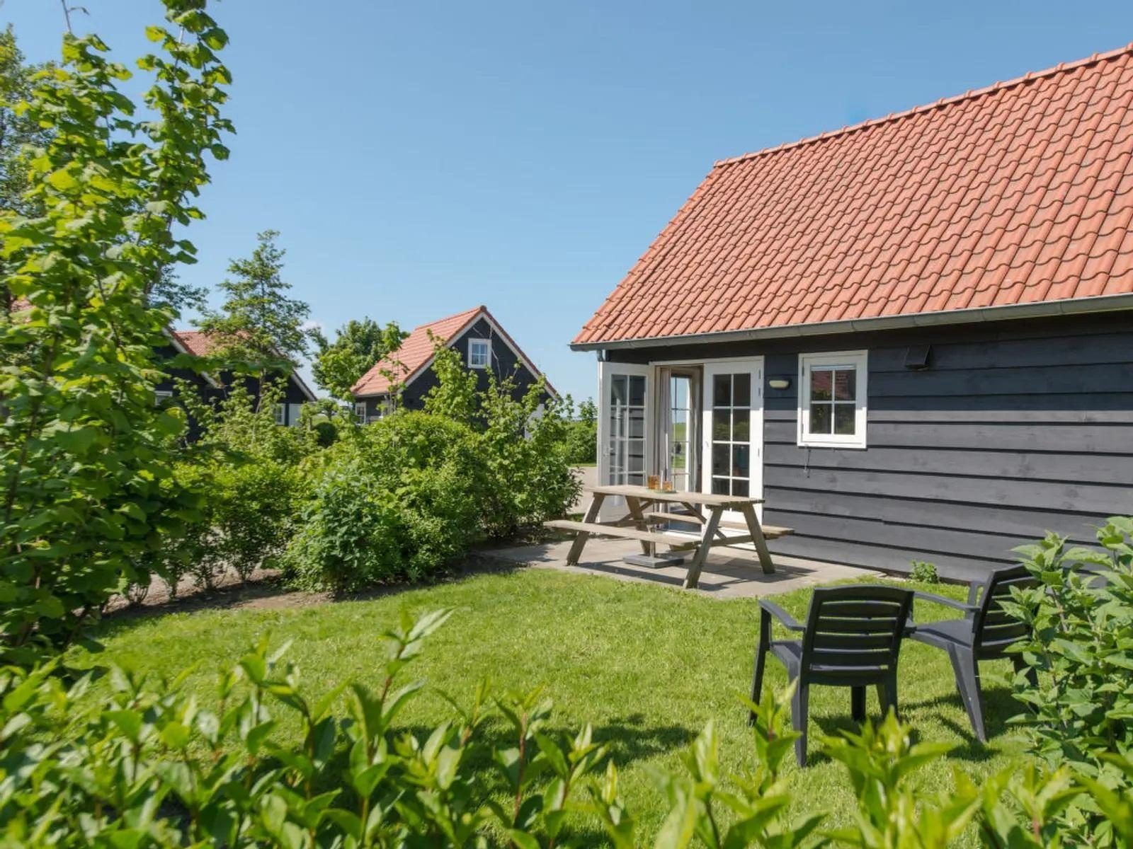 Geniessen Sie das 4-Bett Cottage Zeeland in Wemeldinge, Zuid-Beveland, mit einer sonnigen Terrasse und gruener Umgebung fuer einen entspannten Urlaub.