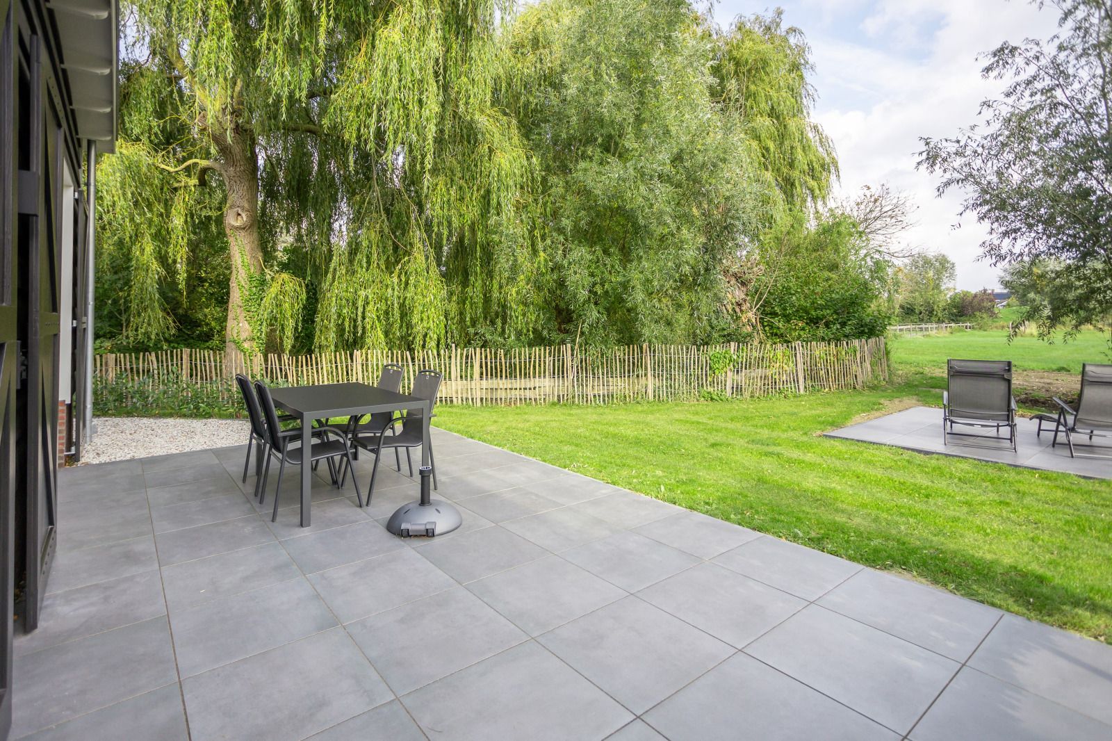 Terrasse des Ferienhauses ZE1455 in Wemeldinge mit Blick auf die gruene Umgebung.