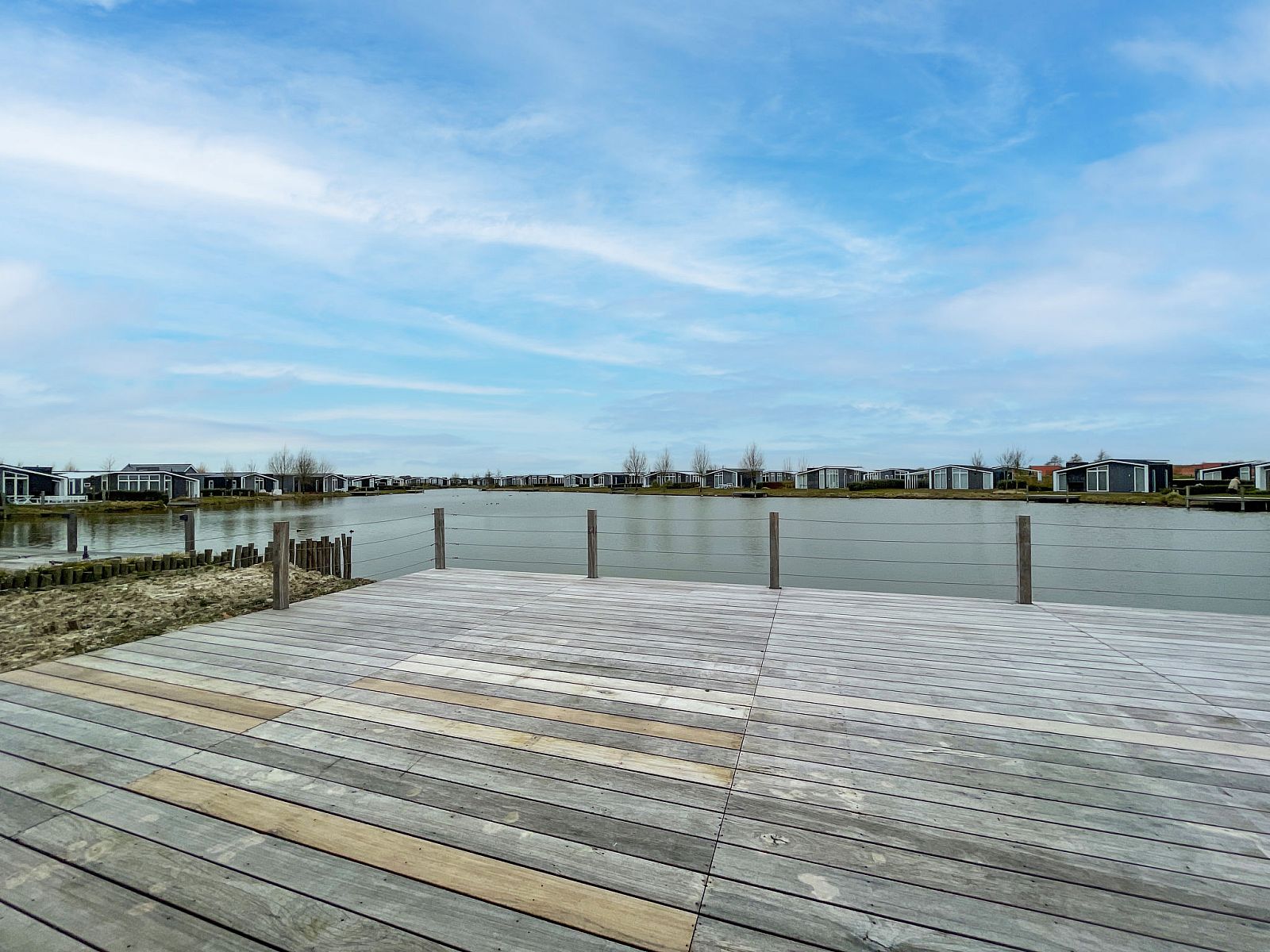Prachtig uitzicht over het water vanaf Vakantiehuis Ruisweg 12, Wemeldinge, Zeeland, met ruime houten vlonder.