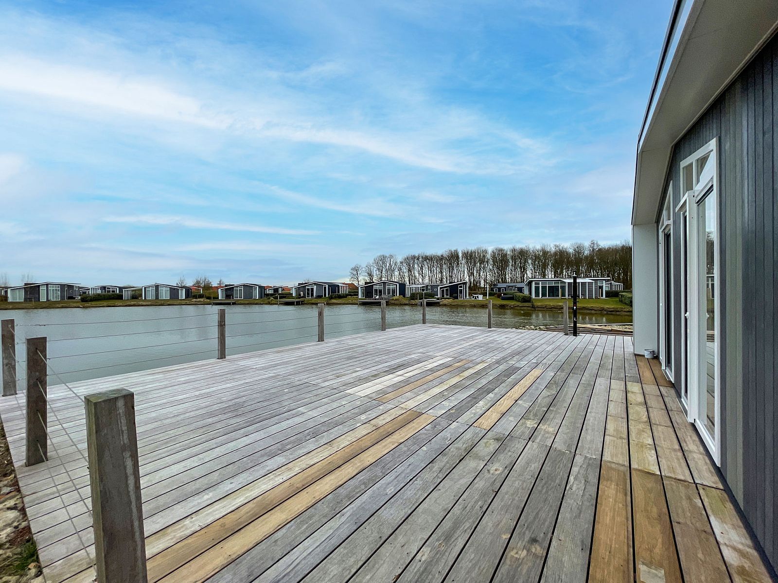 Ruim terras aan het water bij Vakantiehuis Ruisweg 12, Wemeldinge, Zuid-Beveland, ideaal voor ontspanning.
