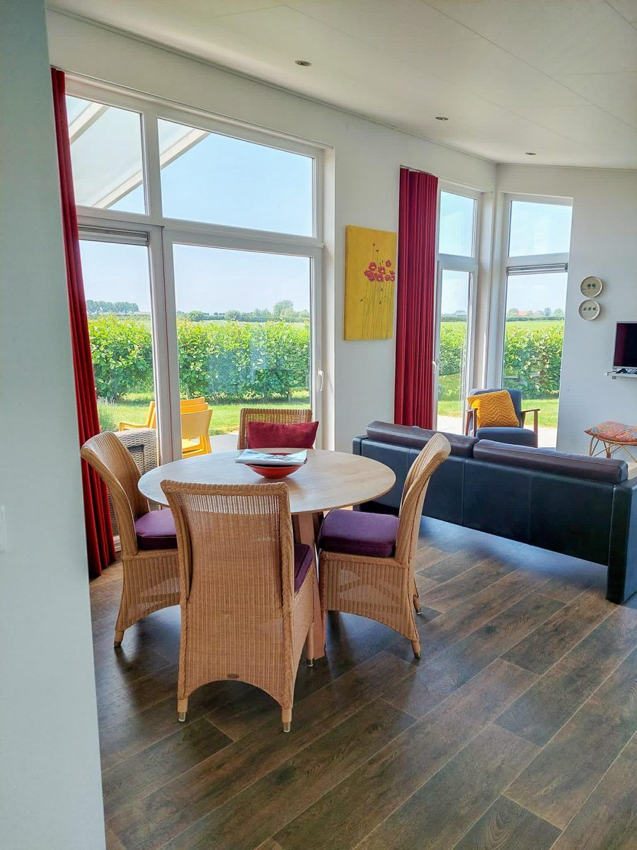 Innenansicht des Ferienhauses Waterresort Oosterschelde Haus Nr. 51, helles Esszimmer mit Blick auf den Garten in Wemeldinge, Zeeland.