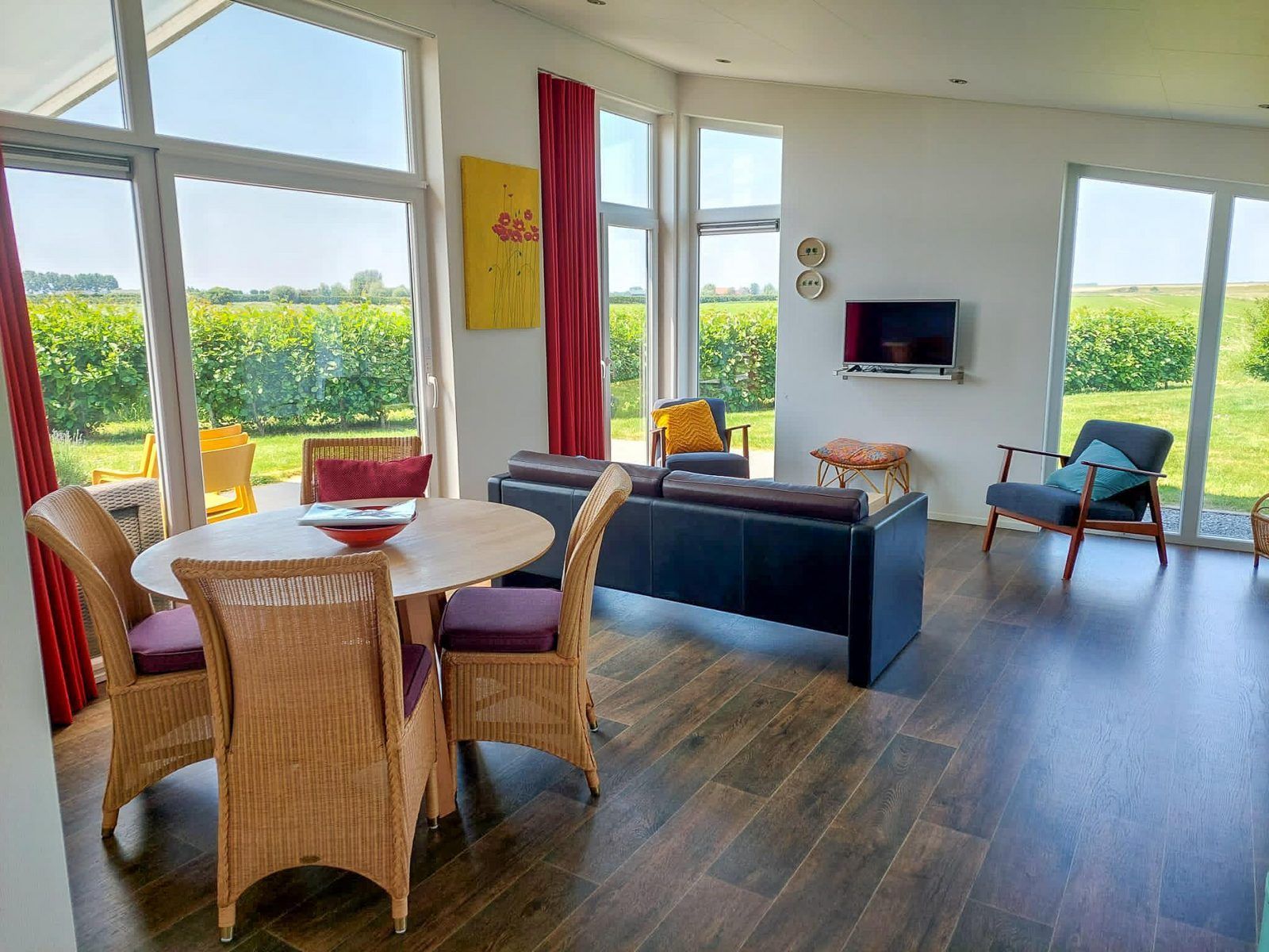 Esszimmer und Wohnzimmer im Ferienhaus Waterresort Oosterschelde Haus Nr. 51, mit viel Licht und Blick auf die Natur in Zeeland.