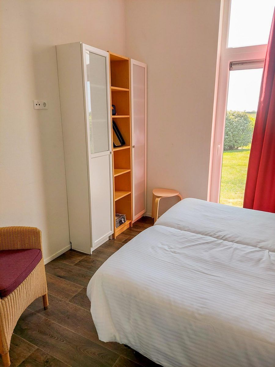 Schlafzimmer im Ferienhaus Waterresort Oosterschelde Haus Nr. 51 in Wemeldinge, mit moderner Einrichtung und Gartenblick.