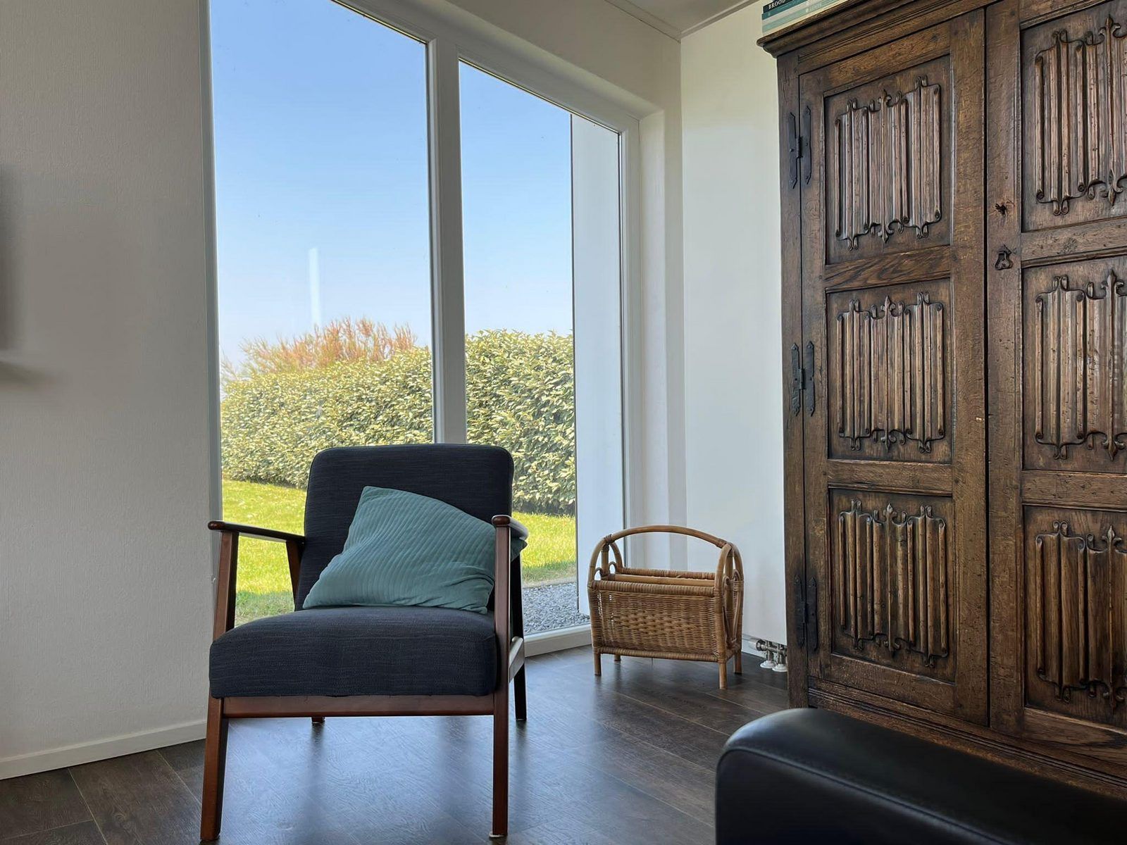 Gemuetliche Leseecke im Ferienhaus Waterresort Oosterschelde Haus Nr. 51, mit antikem Schrank und Gartenblick in Zeeland.