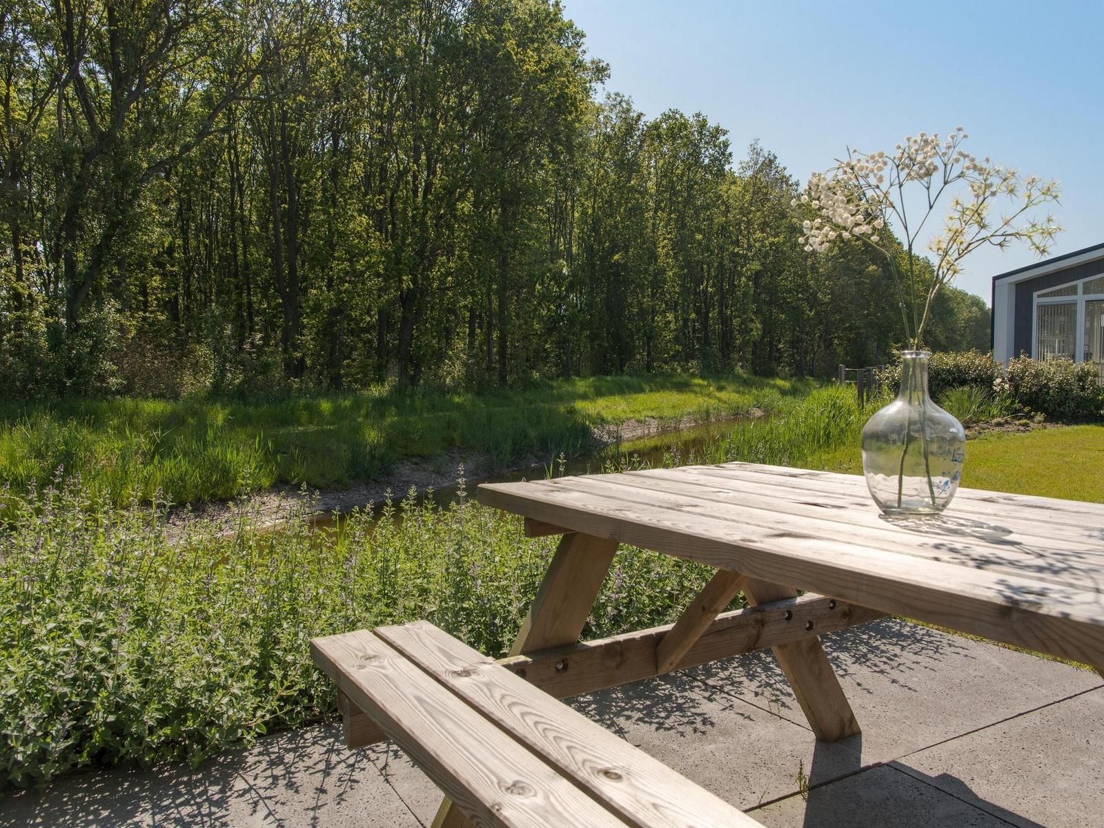 Aussenbereich des Ferienhauses Waterresort Oosterschelde Haus Nr. 93 in Wemeldinge, mit Picknicktisch am Wasser.