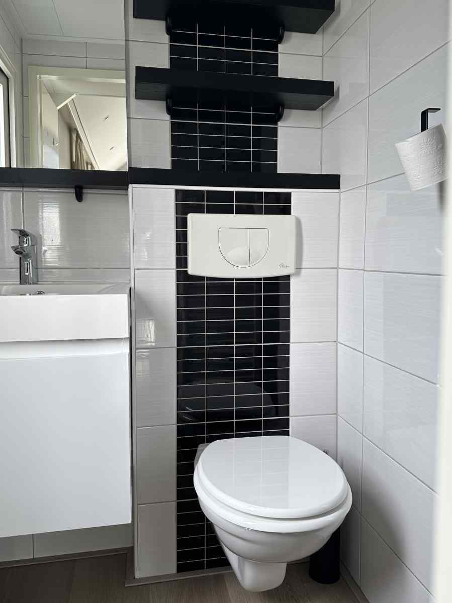 Rustige omgeving van vakantiehuis ZE1365 in Kattendijke, met uitzicht op een groene weide en kerktoren.