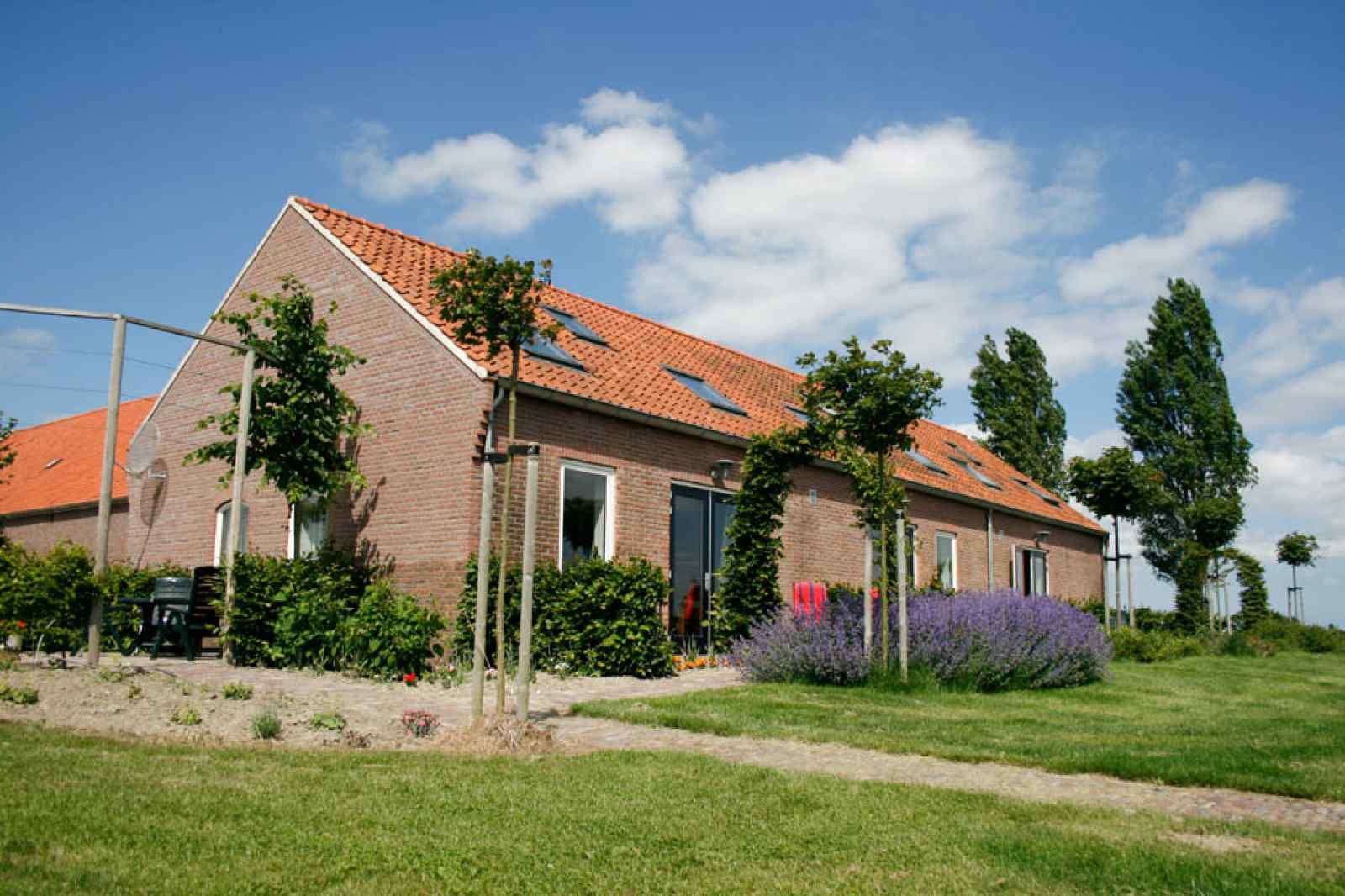 Ferienhaus ZE524 in Kattendijke, Sued-Beveland mit buntem Garten und blauem Himmel.