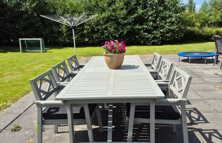 Outdoor dining on the terrace of Cottage in Lewedorp, surrounded by greenery in South Beveland, Zeeland.