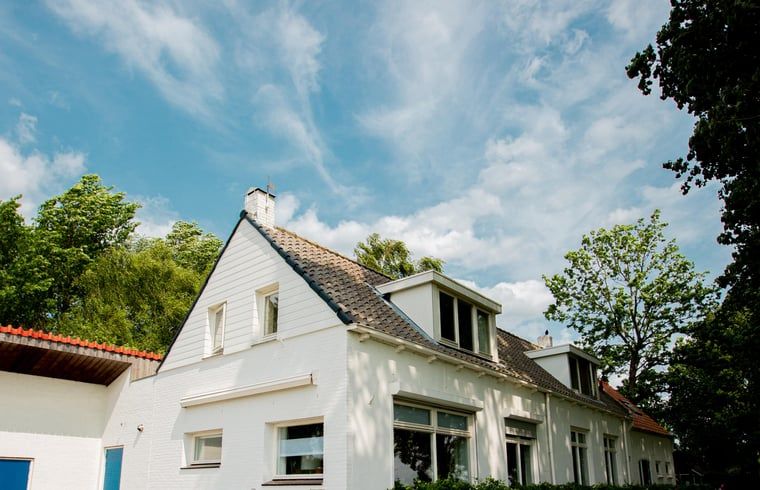 Charmant Vakantiehuisje in Lewedorp, Zuid-Beveland, Zeeland met zonnige gevel en omringd door groene natuur.